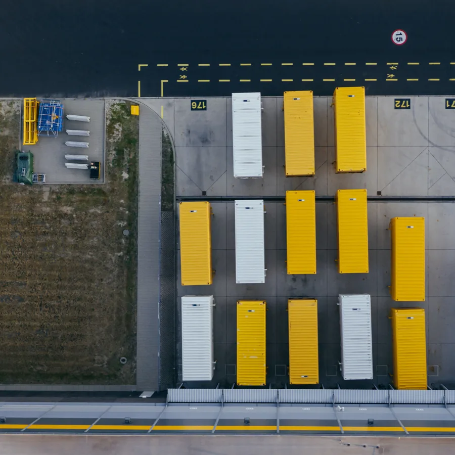 Two warehouse workers and one forklift driver are working in a large warehouse